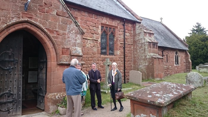 Several people chatting at the entrance to Ruyton Church