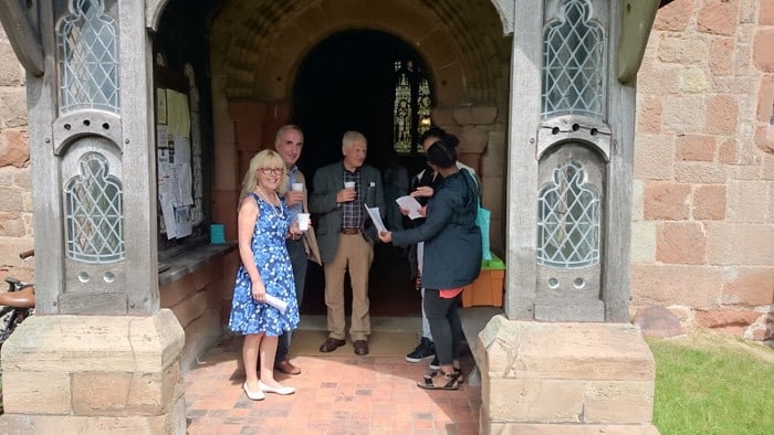 A group of peopl chatting over coffee in the porch of St Martin's church